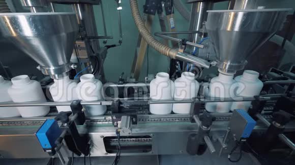 工作设备在移动的传送带上灌装瓶子自动化生产线视频的预览图