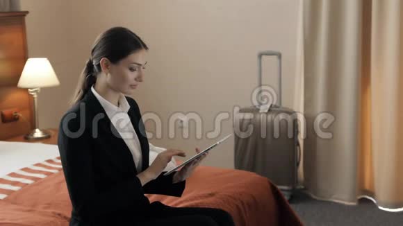 商务技术互联网和酒店概念幸福的年轻女商人带着平板电脑躺在酒店里视频的预览图