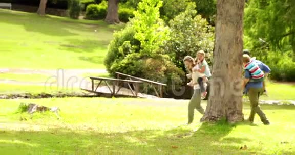 快乐的一家人一起在公园里玩追逐游戏视频的预览图