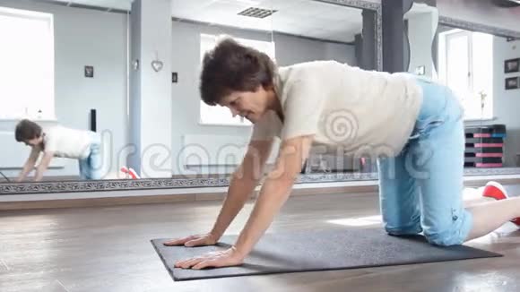 老年妇女在健身室伸展身体练习瑜伽视频的预览图