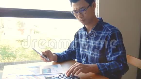 摄影认真的亚洲商人工作与纸张工作和计算器计算文件商业会计视频的预览图