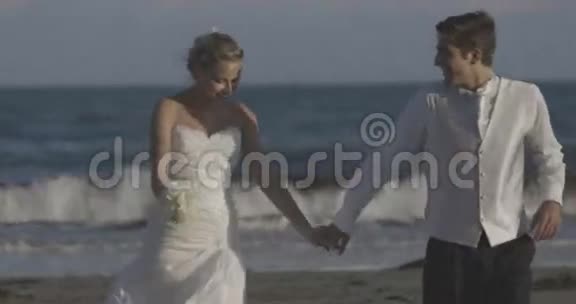 微笑着新婚夫妇在海滩上奔跑视频的预览图