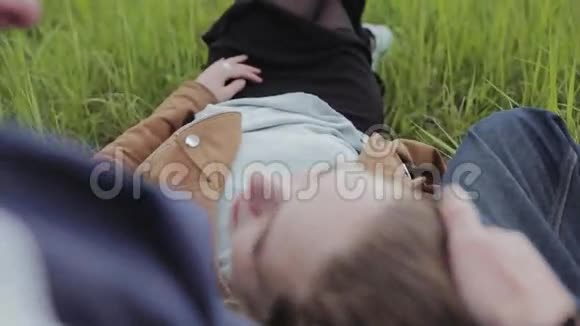 恋人们躺在草地上聊天快乐的微笑视频的预览图