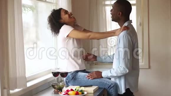 快乐的非洲浪漫的年轻夫妇在厨房享受快乐视频的预览图