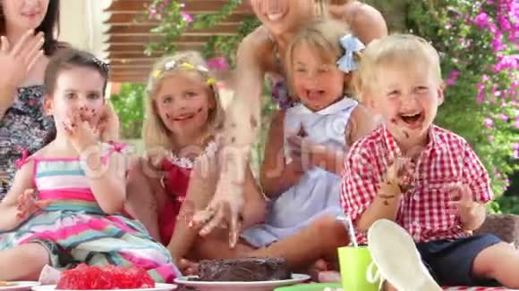家长和孩子在派对上享用巧克力蛋糕视频的预览图