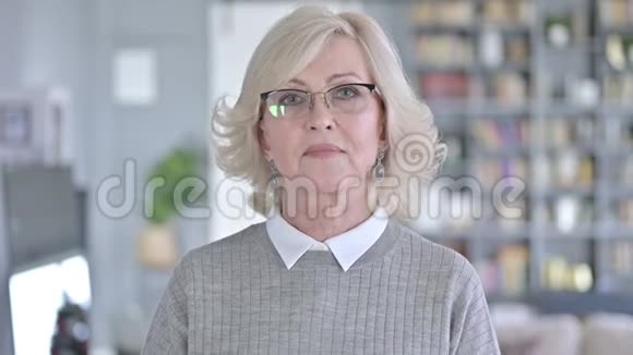 镜头前微笑的老女人的肖像视频的预览图
