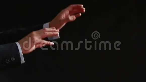 指挥音乐家的管弦乐队指挥的手特写镜头黑色背景视频的预览图