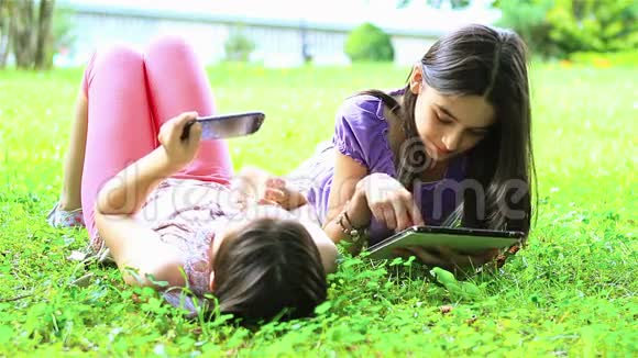 女孩在数码平板电脑和智能手机上玩得开心视频的预览图
