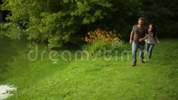 英俊的男朋友背着女孩浪漫的情侣在夏天在城市公园的户外玩得很开心视频的预览图