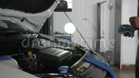 用油尺检查油位诊断系统机器汽车服务年轻的专家修理视频的预览图