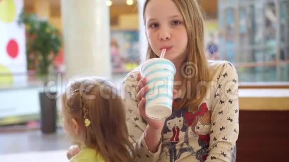 可爱的小女孩肖像有趣的吃快餐场在商场视频的预览图