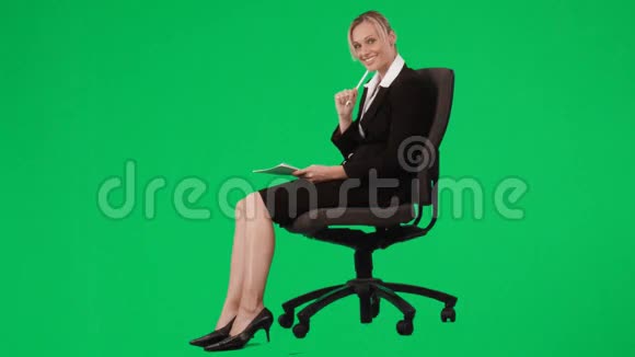 女商人坐在椅子上用绿色屏幕写笔记视频的预览图