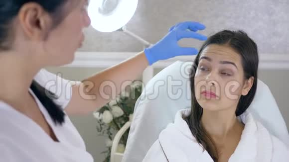 美容师在美容院的特写中咨询女士面部肉毒毒素注射视频的预览图