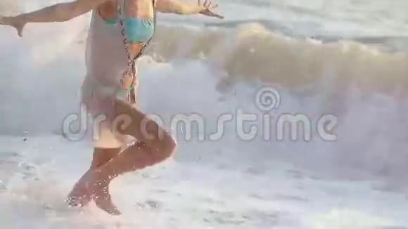 快乐的女孩沿着海滩奔跑享受着视频的预览图