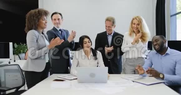 商务人士集体拍手聚合商务女性在笔记本电脑上展示新项目团队快乐视频的预览图