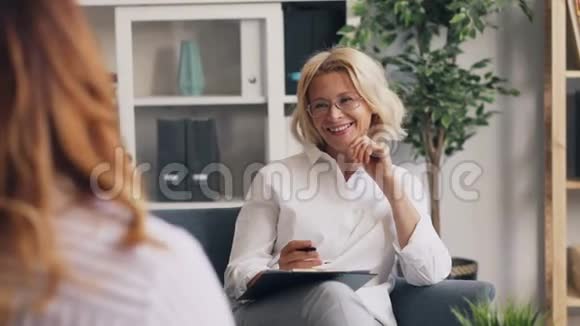 积极精神分析人士在与女性病人交谈时笑着视频的预览图