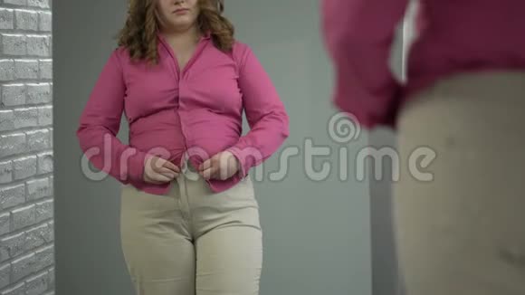 女士用力把衬衫扣在肚子上肥胖健康问题视频的预览图