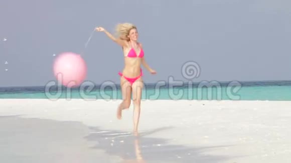 比基尼女郎带着气球在美丽的海滩上奔跑视频的预览图