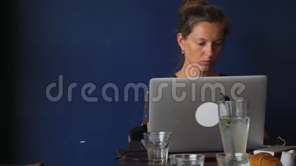 布鲁内特在咖啡馆里拿着笔记本电脑视频的预览图