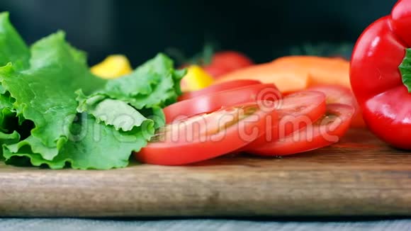 沙拉叶切好的番茄胡椒和胡萝卜放在木板上做健康的蔬菜沙拉小圆片视频的预览图
