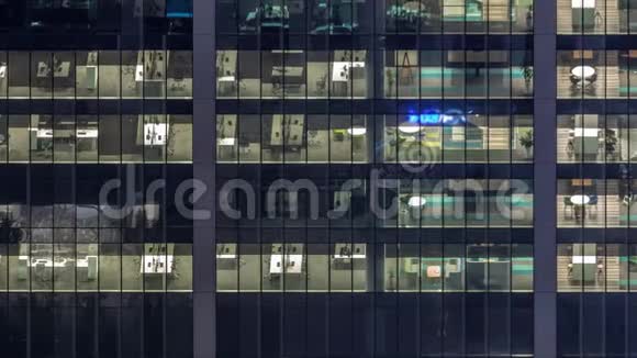 办公大楼在深夜外部内部灯亮着人们在夜间工作视频的预览图