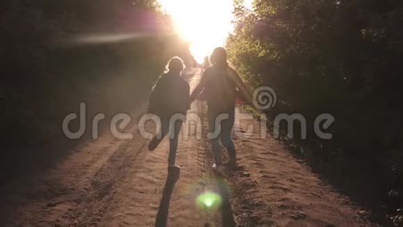 儿童旅行者徒步旅行者女孩带着背包的快乐女孩旅行者牵着双手在乡间小路上奔跑视频的预览图