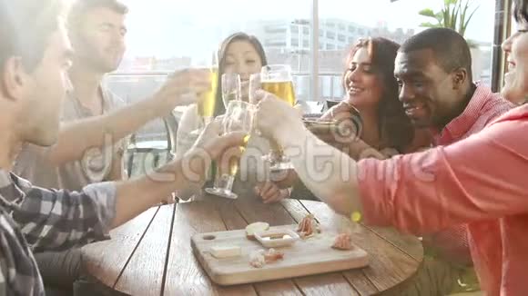 在屋顶酒吧享受饮料和小吃的朋友小组视频的预览图