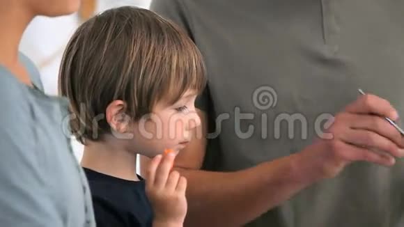 男孩吃蔬菜而他的父亲在端盘子视频的预览图