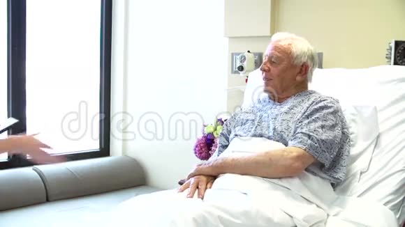 顾问在医院病房与资深男性病人谈话视频的预览图