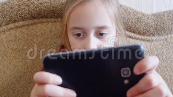 少女坐在沙发上玩电话视频的预览图