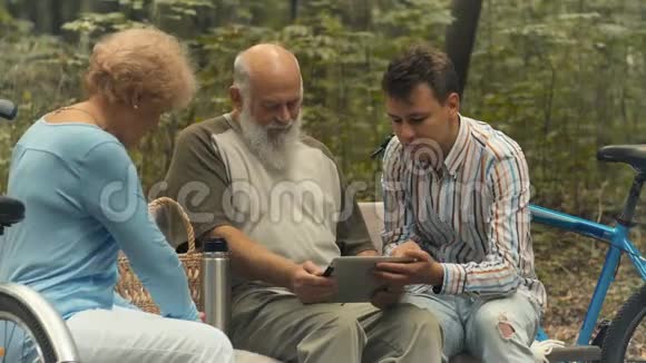 年轻人向老年人展示如何使用平板电脑视频的预览图