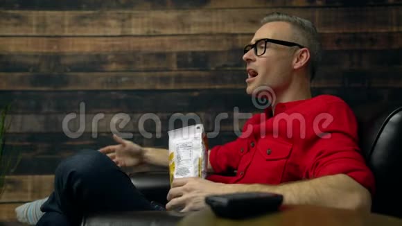 吃饭的时候坐着的男人对电视大喊大叫视频的预览图