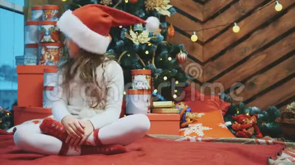 小女孩坐在洛托斯的位置上把头从一边移动到另一边这样圣诞老人的帽子就会稍微击中她的脸视频的预览图