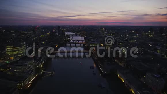 美丽的粉红色日落天空在泰晤士河上明亮的夜晚灯光伦敦市中心建筑空中全景视频的预览图
