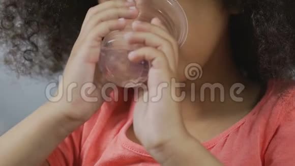 小非洲裔美国女孩从塑料玻璃喝清水饮料视频的预览图