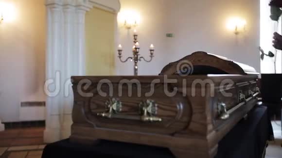 葬礼上悲伤的女人把红玫瑰放进棺材里视频的预览图