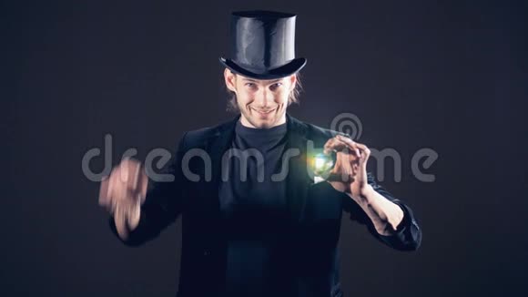 魔术师正在使一个闪闪发光的水晶从他的右拳消失并从空中采取视频的预览图