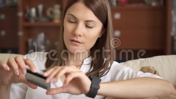 美丽的女性网上银行使用智能手表在线购物与信用卡家庭生活方式视频的预览图
