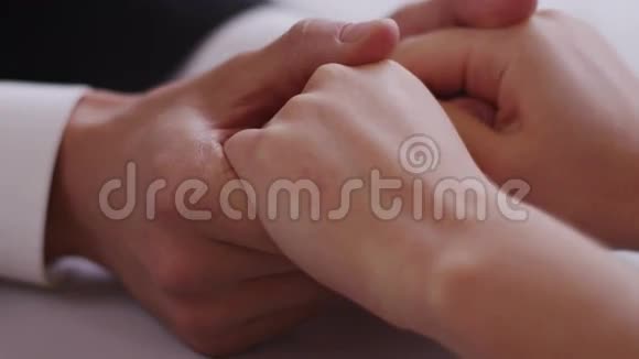 一对年轻夫妇坐在一张桌子旁手握4K红色数码影院镜头视频的预览图