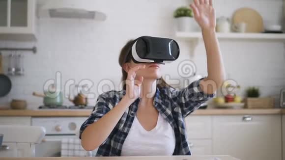 一位年轻女子正在家里的厨房里测试虚拟现实眼镜视频的预览图