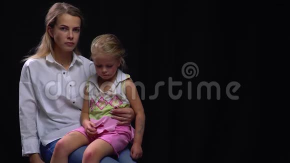 愤怒的母亲把被殴打的女儿抱在膝上虐待儿童社会问题视频的预览图