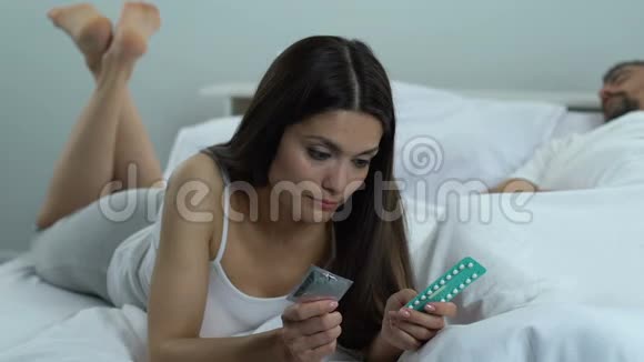 妻子躺在床上选择避孕套或口服药避孕方法安全性行为视频的预览图