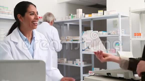 微笑的药剂师把纸递给顾客视频的预览图