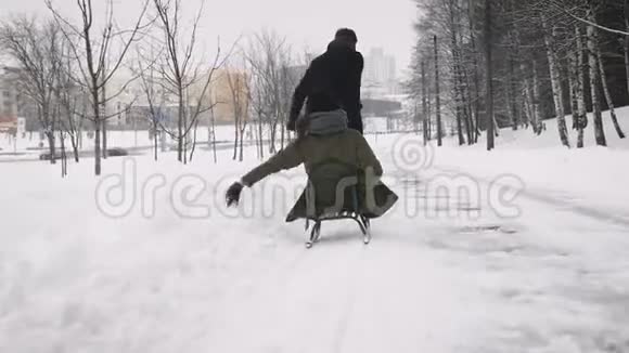男人在雪地上拉着女孩视频的预览图