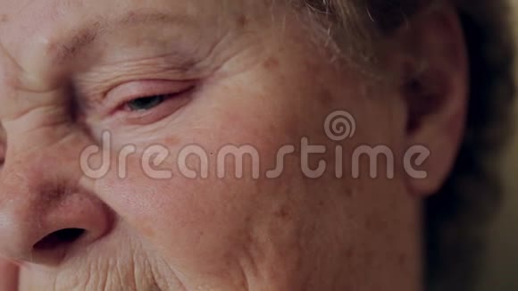 特写老年妇女眼睛照片高级肖像戴着眼镜的幸福老妇人微笑着看着相机视频的预览图