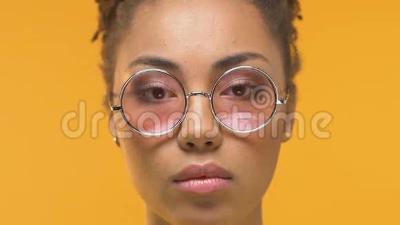 年轻的非洲妇女摘下眼镜看着镜头震惊皮肤科视频的预览图