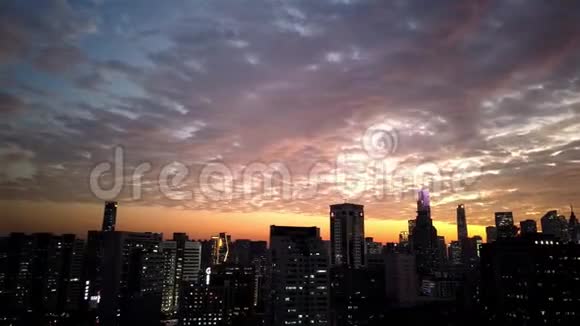 天空五彩缤纷的云流城市建筑上的日落时光流逝视频的预览图