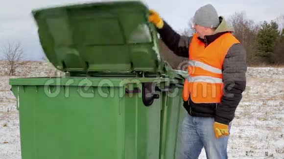 冬天集装箱附近有垃圾袋的工人视频的预览图
