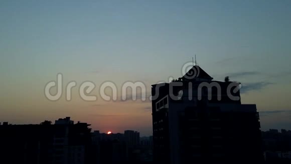 日出的城市建筑在黎明的天空中五彩缤纷的云流时光流逝视频的预览图
