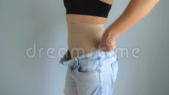穿着紧身内裤的女人把牛仔裤放在上面检查结果追求完美身材的理念视频的预览图